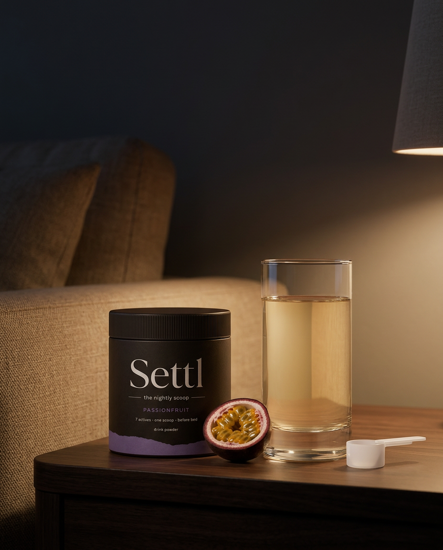 Settl tub, a glass and a halved passionfruit on a side table in warm lamp light.