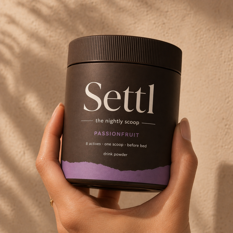 Settl tub of nightly sleep powder beside a glass of mixed cold water.