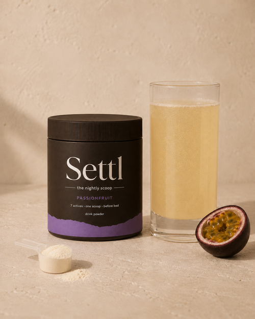 Settl tub with a glass of passionfruit drink, scoop of powder and halved passionfruit